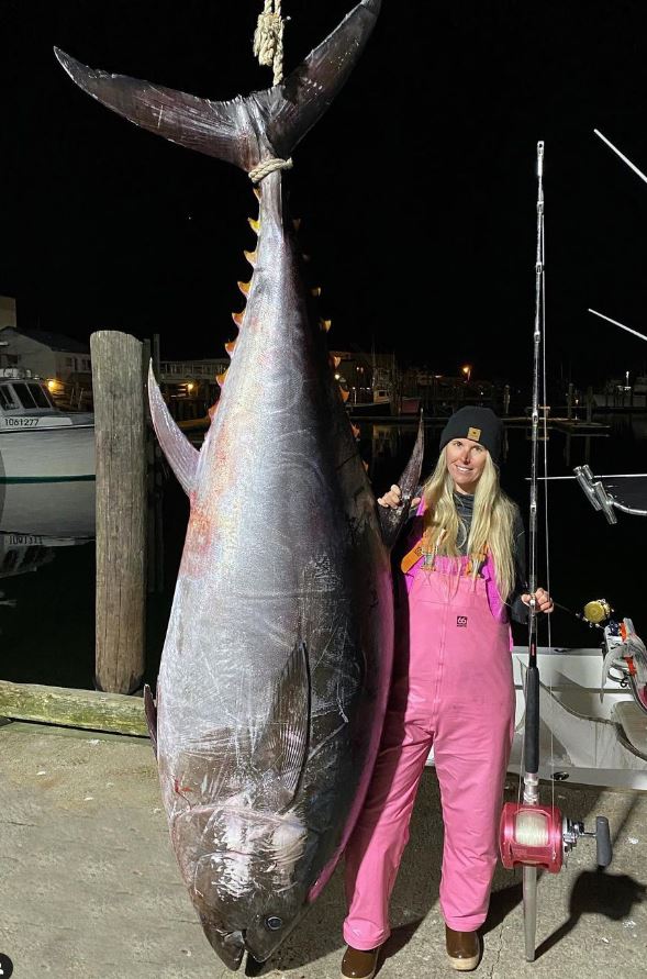 Lady in Pink standing with giant tuna fish
