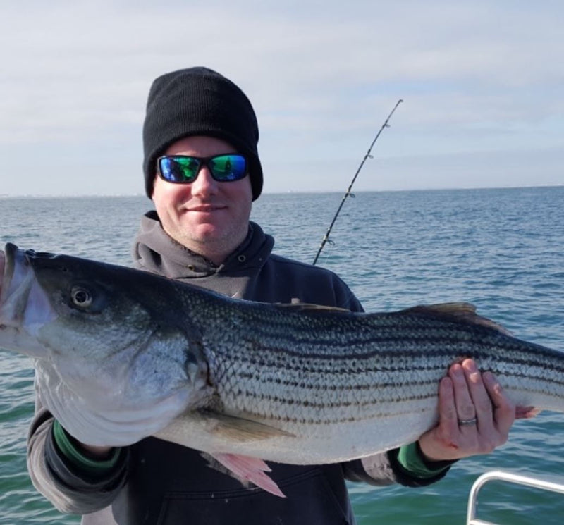 Man holding a Striper Fish in NJ
