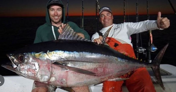 Two men holding Tuna Fish