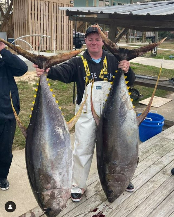 Man Holding two tuna fish